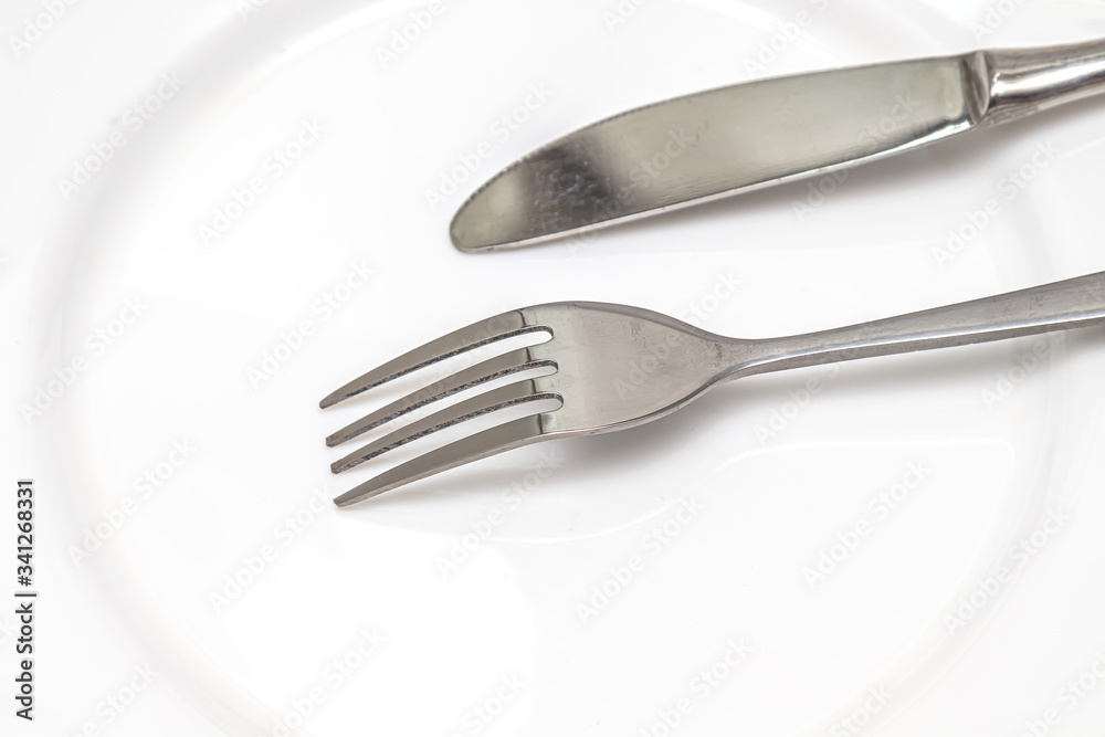 Steel fork and knife close-up on a white background Steel fork and knife close-up on a white background