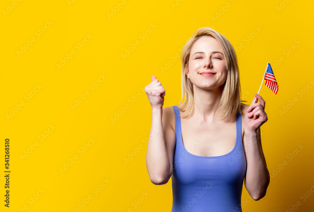 Beautiful blonde woman with USA flag on yellow background Beautiful blonde woman with USA flag on yellow background