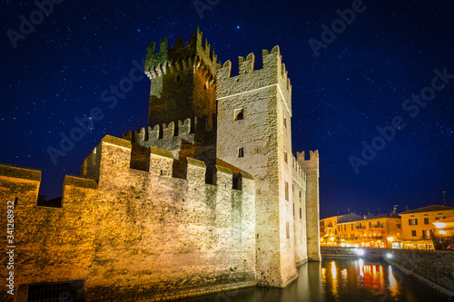 Scaligero Castle over the Garda lake in Sirmione at night, Italy photo