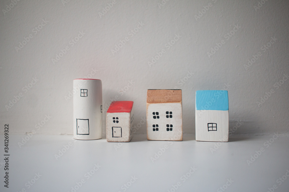 small wooden houses in a row on white background. Stay at home. Be at home together. Social distancing.Stay at home during coronavirus. Homeless need home. Buy house. House for rent. small wooden houses in a row on white background. Stay at home. Be at home together. Social distancing.Stay at home during coronavirus. Homeless need home. Buy house. House for rent.