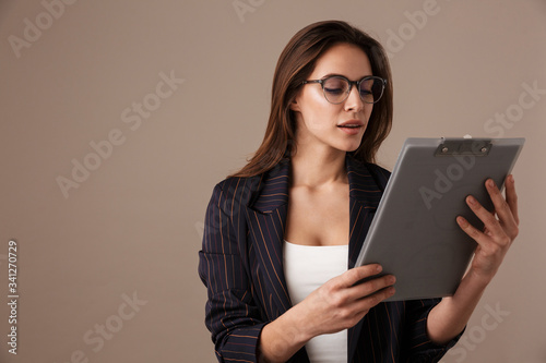 Photo of focused businesswoman in eyeglasses posing with clipboard