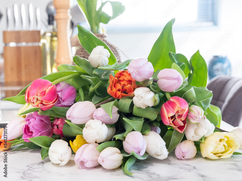 multi-colored tulips are loose on the kitchen counter