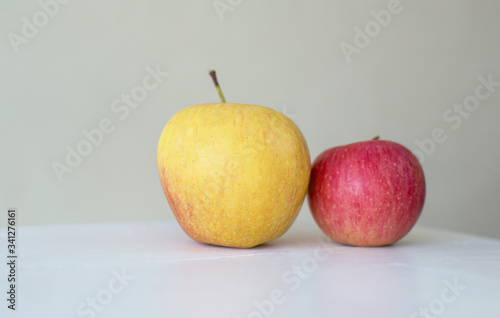 big and small red apples isolated on white wood table