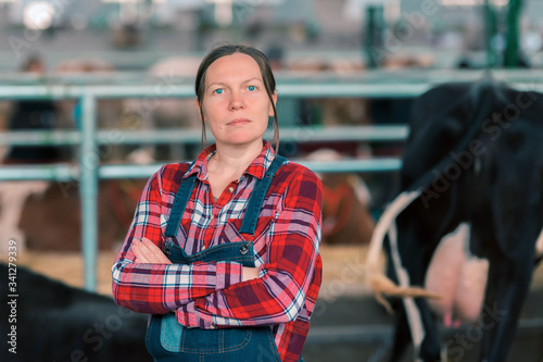 Female farmer in cow shed on a dairy livestock farm