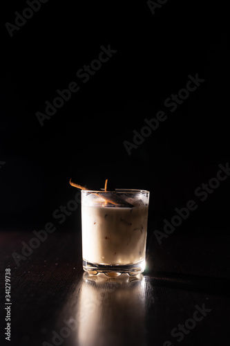 cream alcoholic cocktail with mint leaves on a neutral black background white Russian