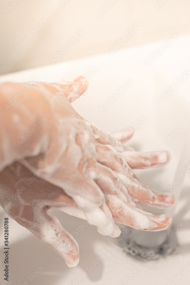 Fototapeta premium Washing hands with soap under the faucet with water. Hygiene concept.