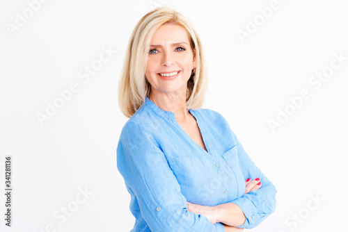 Attractive senior woman standing with arms crossed at isolated white background