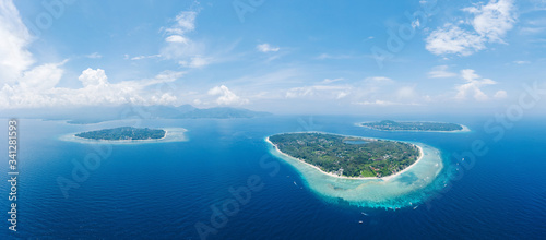 Amazing aerial view to Gili islands and Lombok. Unforgettable experience during vacations holidays. Blue sky and lagoon water. Clouds on the horizon. Air, Meno, Trawangan. photo
