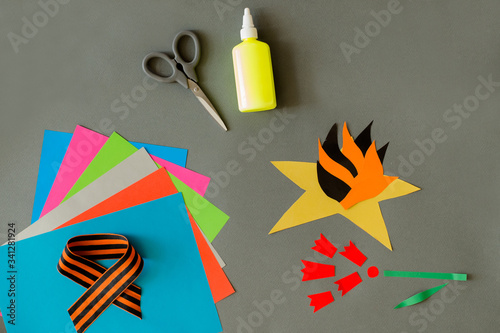 step by step craft applique for children eternal flame and flowers 2 red carnations on an isolated gray background on the theme of Victory Day May 9 Great Patriotic War