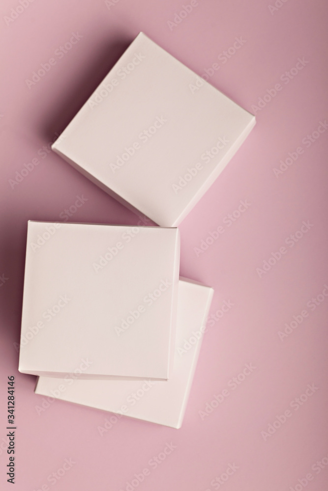 Stack of white cardboard boxes on a pink background with copyspace for your text Stack of white cardboard boxes on a pink background with copyspace for your text