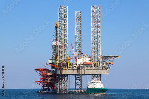 Offshore oil platform and supply ship are in Persian Gulf. photo