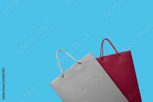 Red and gray paper shopping bag isolated on blue background