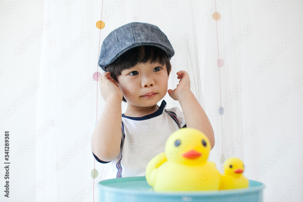 Portrait of cute Asian toddler wearing farmer's flat cap having fun and playing with toys at home. Portrait of cute Asian toddler wearing farmer's flat cap having fun and playing with toys at home.