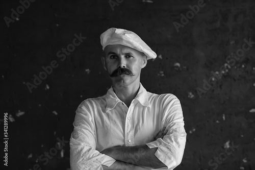 Portrait of a brutal mustachioed cook, in the profession uniform, white cap. glasses man