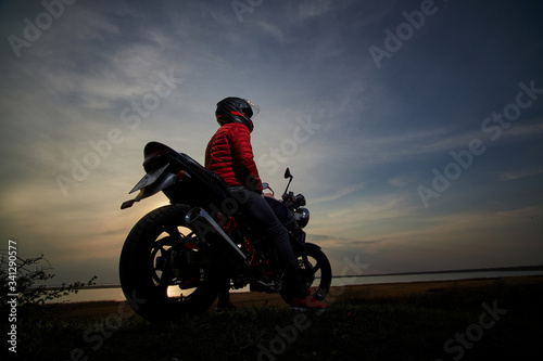 Fototapeta Naklejka Na Ścianę i Meble -  
young man with a motorcycle at sunset