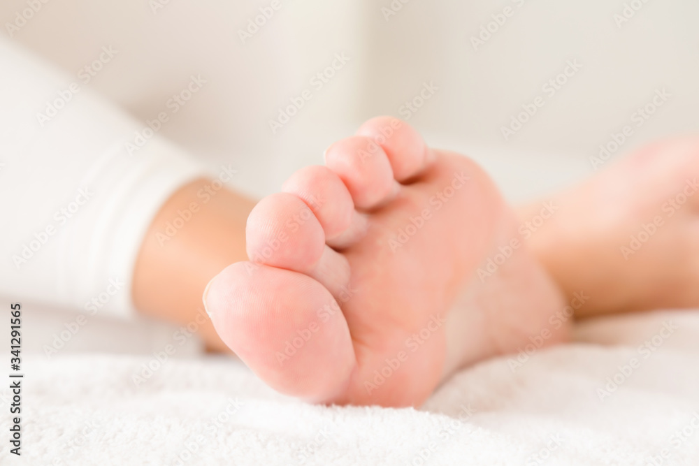 Young, perfect, clean woman foot relaxing on bed. Closeup. Young, perfect, clean woman foot relaxing on bed. Closeup.