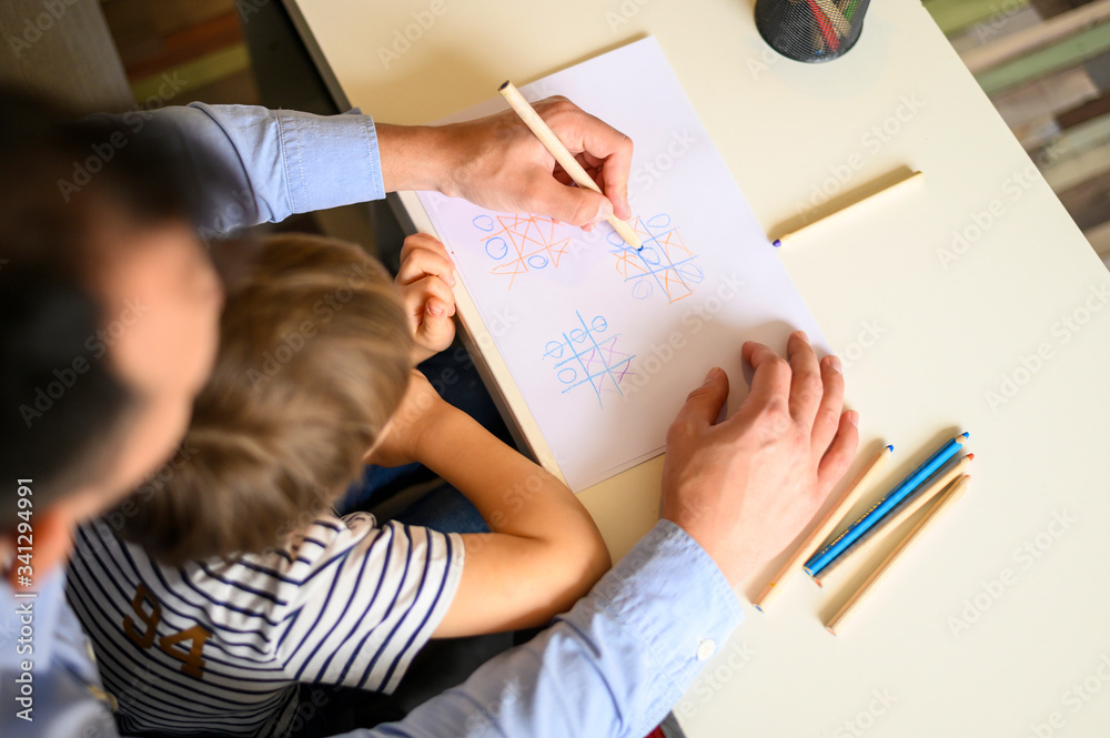 Father and son playing game tic tac toe Father and son playing game tic tac toe