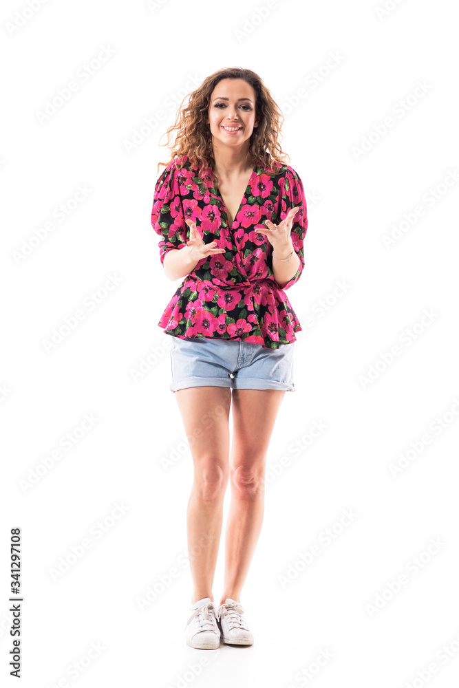 Happy polite helpful young woman talking and explaining while gesticulating with hands looking at camera. Full body isolated on white background. Happy polite helpful young woman talking and explaining while gesticulating with hands looking at camera. Full body isolated on white background.