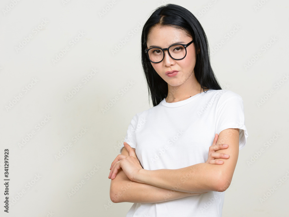 Portrait of stressed young Asian nerd woman with arms crossed