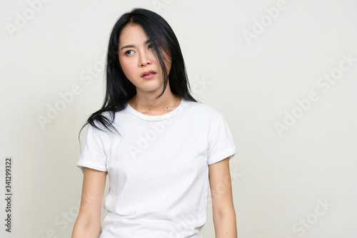 Portrait of stressed young Asian woman looking tired