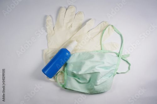 Surgical mask, medical gloves and sanitizer in bottle. White background. 