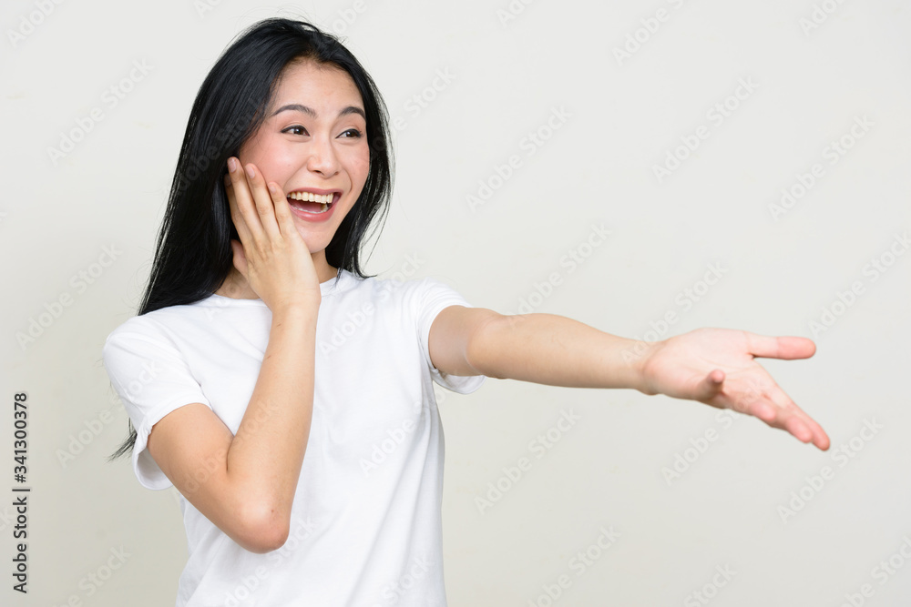 Portrait of happy young beautiful Asian woman looking surprised Portrait of happy young beautiful Asian woman looking surprised