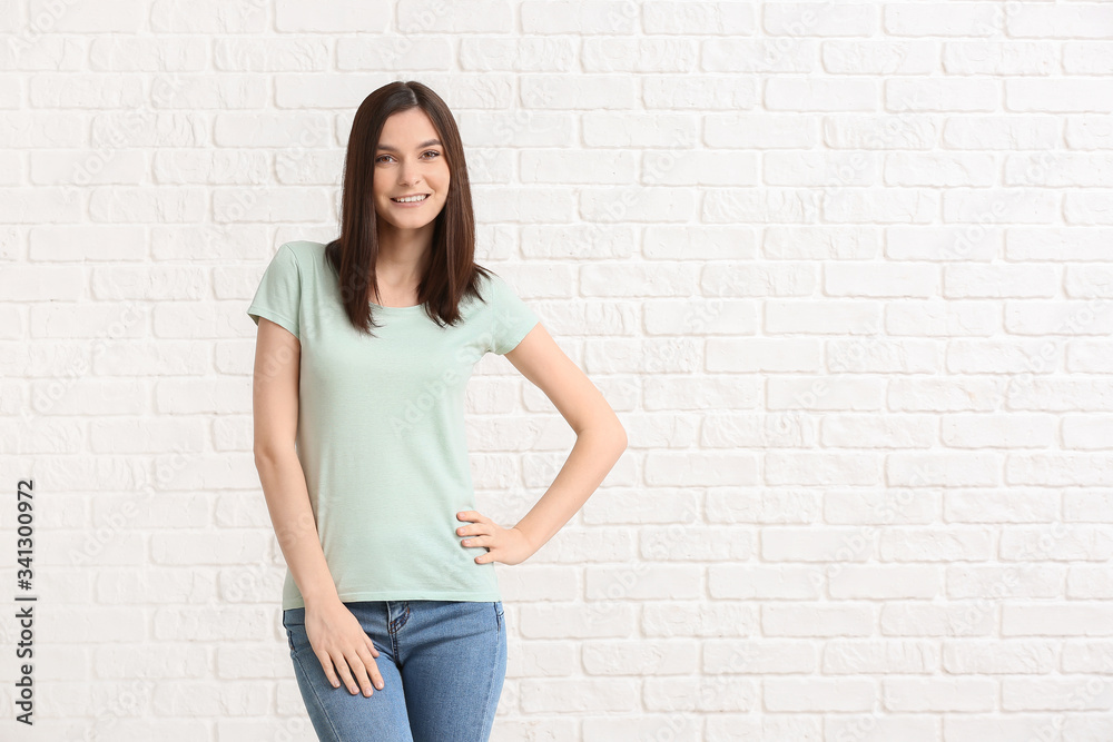 Woman in stylish t-shirt on white brick background Woman in stylish t-shirt on white brick background