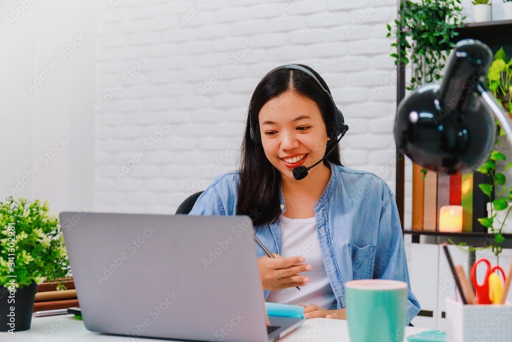 Asian business woman work from home with laptop computer on table with meeting online and video conferencing.Concept of social distancing to stop the spread disease of Corona virus. Asian business woman work from home with laptop computer on table with meeting online and video conferencing.Concept of social distancing to stop the spread disease of Corona virus.