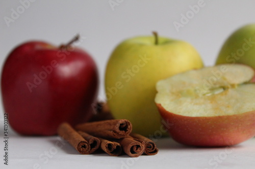 cinnamon sticks and apples on a white background