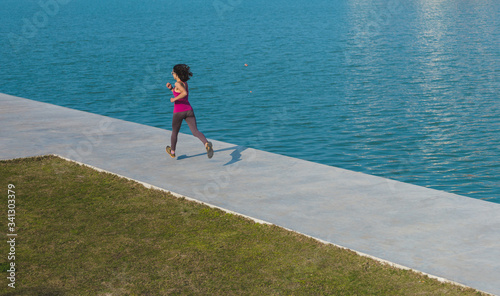 A woman runs along the city promenade along the river.