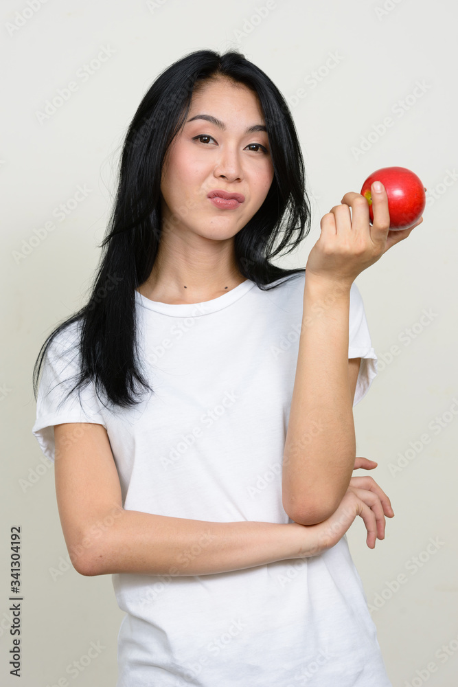 Portrait of young beautiful Asian woman holding apple Portrait of young beautiful Asian woman holding apple