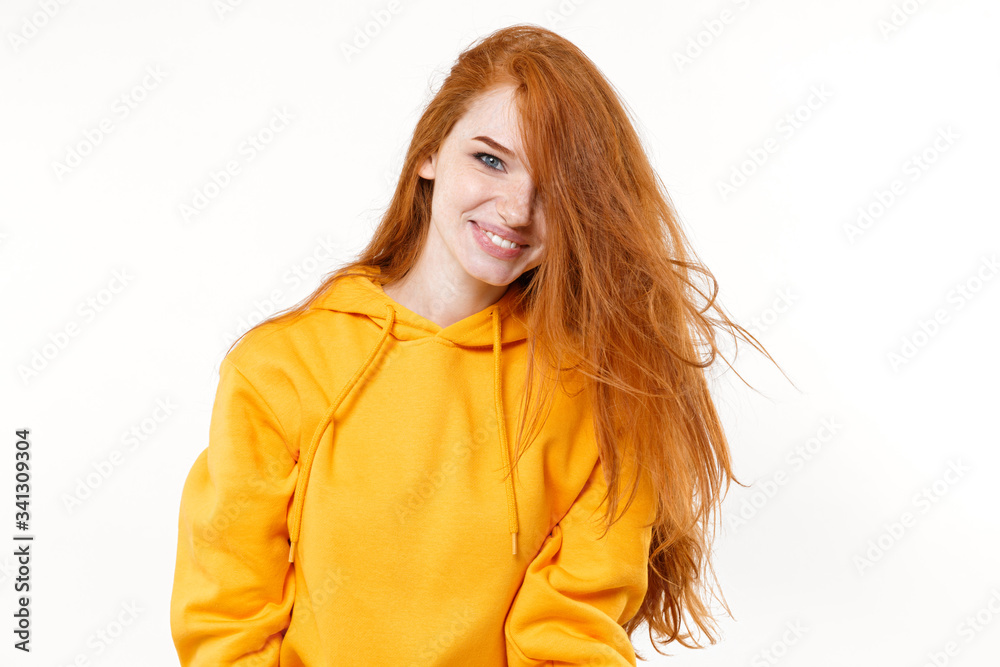 Smiling attractive young redhead woman girl in casual yellow hoodie posing isolated on white background studio portrait. People sincere emotions lifestyle concept. Mock up copy space. Looking camera. Smiling attractive young redhead woman girl in casual yellow hoodie posing isolated on white background studio portrait. People sincere emotions lifestyle concept. Mock up copy space. Looking camera.