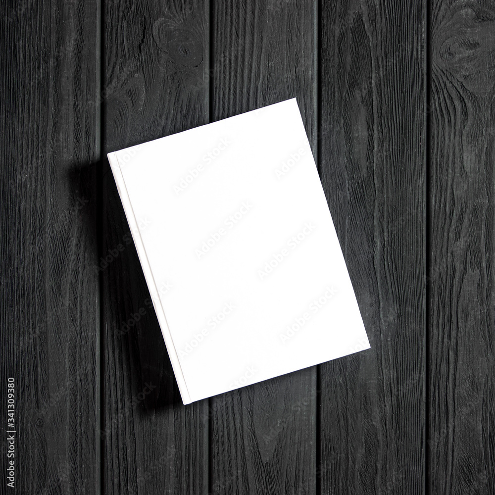 Mockup of closed blank square book at white textured paper Mockup of closed blank square book at white textured paper