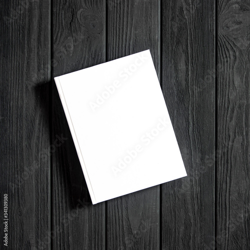 Mockup of closed blank square book at white textured paper