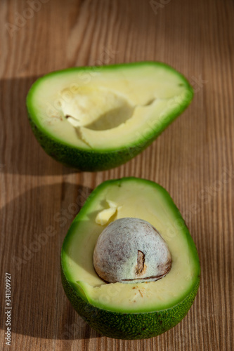 Top view of a cut avocado, on wooden board, vertical
