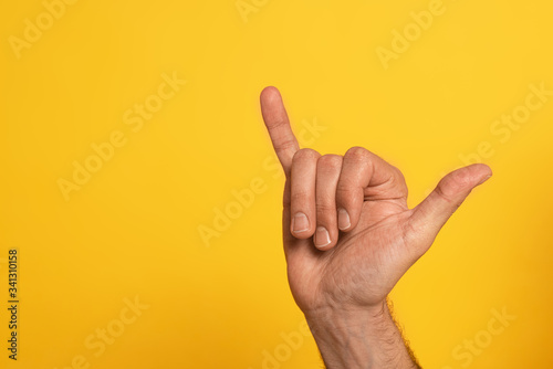 Cropped view of man showing cyrillic letter from alphabet of sign language isolated on yellow