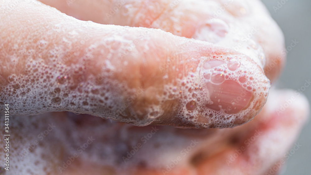 Fototapeta premium Covid - 19 Coronavirus prevention. A man wash our hands with antibacterial soap. Corona pandemic protection by frequent hand washing. Selective focus