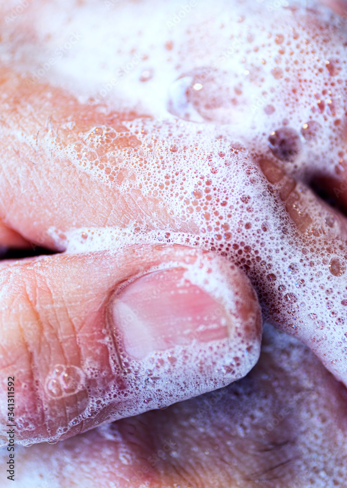 Fototapeta premium Covid - 19 Coronavirus prevention. A man wash our hands with antibacterial soap. Corona pandemic protection by frequent hand washing. Selective focus