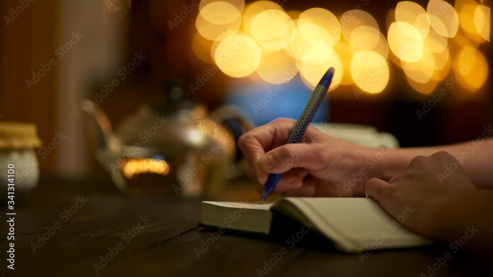 Woman writing notes in her note book using pen. Keeping her diary, beeing creative, writing poetry and new food recipes. Panoramic shot, 4K
