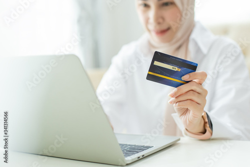 credit card to pay, asian beautiful muslim women honding to payment and shopping online. photo