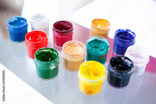  jars of gouache on a glass table indoors