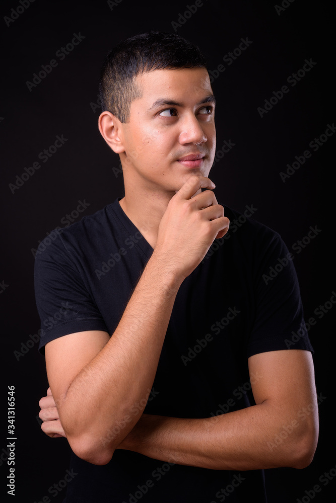 Portrait of young handsome Asian man thinking Portrait of young handsome Asian man thinking