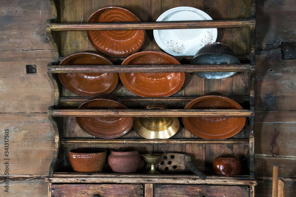 a cupboard for dishes in an old rural house, earthenware, large plates, cast iron, pot a cupboard for dishes in an old rural house, earthenware, large plates, cast iron, pot