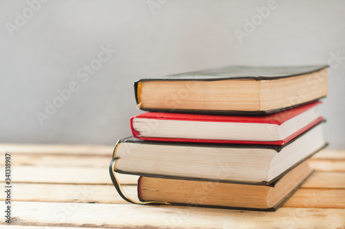 A stack of books on a wooden table.