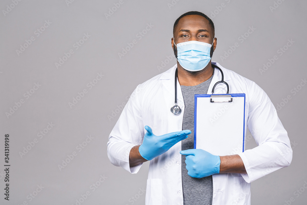 African american doctor man in face mask gloves isolated on grey background. Epidemic pandemic coronavirus 2019-ncov sars covid-19 flu virus. Holding clipboard. African american doctor man in face mask gloves isolated on grey background. Epidemic pandemic coronavirus 2019-ncov sars covid-19 flu virus. Holding clipboard.