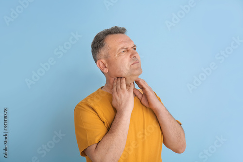 Mature man checking thyroid...