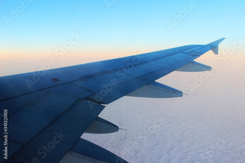 Wing of the plane sunrise sky background