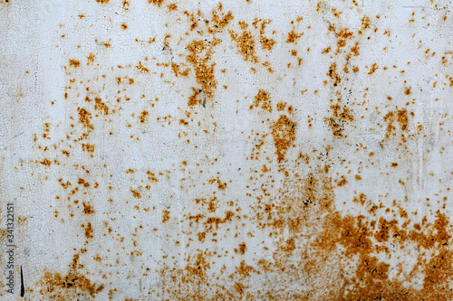 Metal surface with white paint that has passed temporary damage, a lot of formed, red rust. Textured background with traces of destruction and deformation