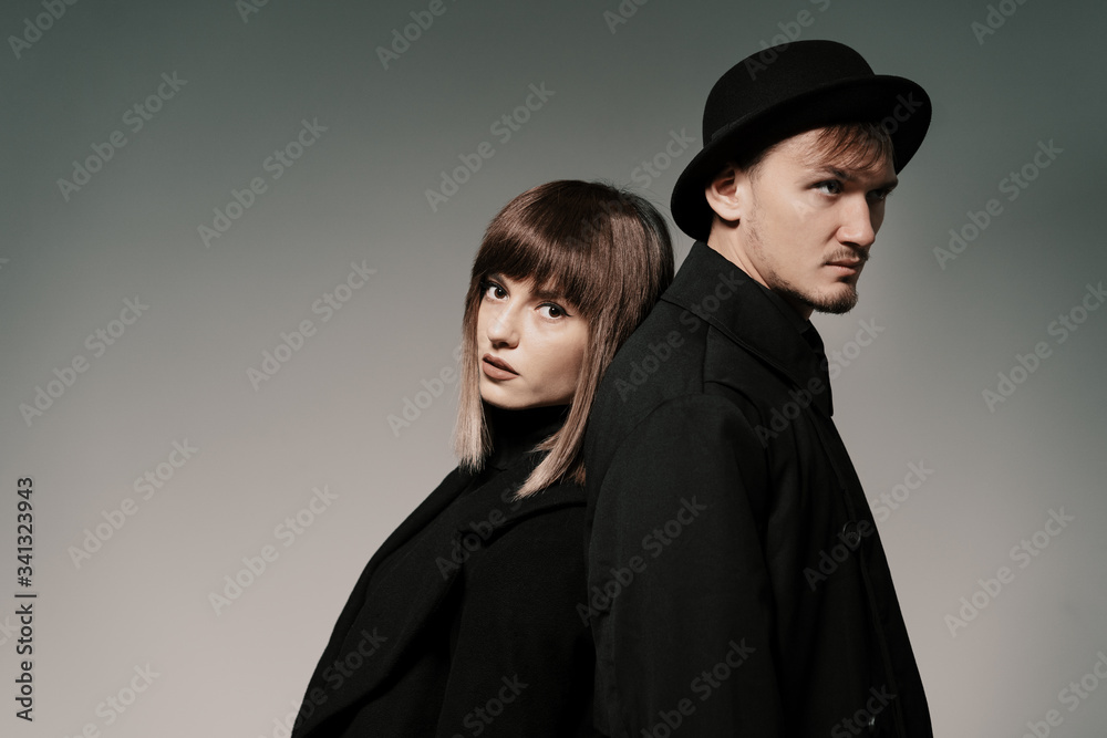 Portrait of urban fashion beautiful couple in black clothes posing over gray background together. Close up fashion portrait of stylish young couple pretty woman and handsome man Portrait of urban fashion beautiful couple in black clothes posing over gray background together. Close up fashion portrait of stylish young couple pretty woman and handsome man