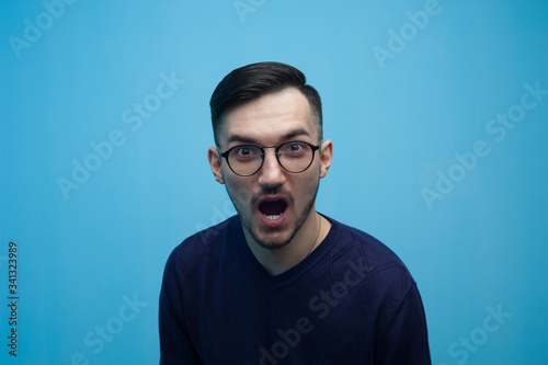 Portrait of an emotional young man in glasses